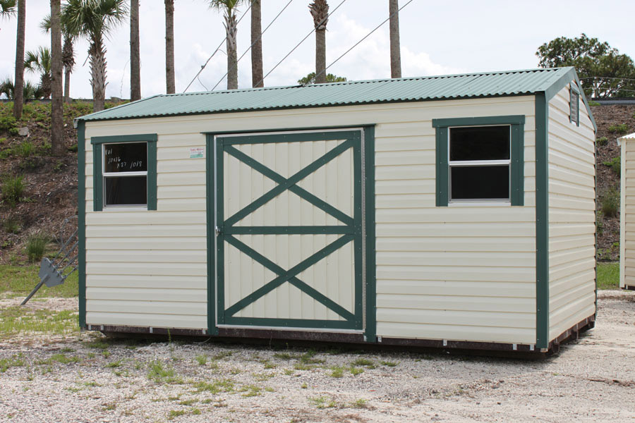 Beige aluminum shed with green trim on display
